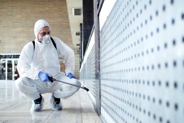 people white chemical protection suit doing disinfection to stop spreading diseases